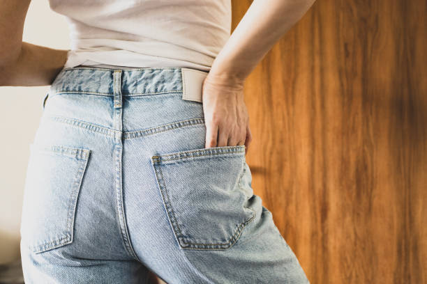 rear view of a woman wearing denim trousers - fashion stock pictures, royalty-free photos & images
