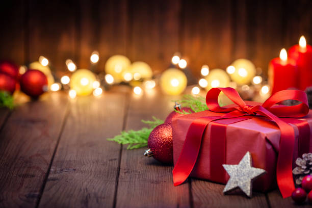 red christmas gift box on rustic wooden table - home decoration stock pictures, royalty-free photos & images