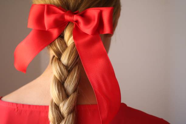 red ribbon tied on braided hair - hairstyle stockfoto's en -beelden