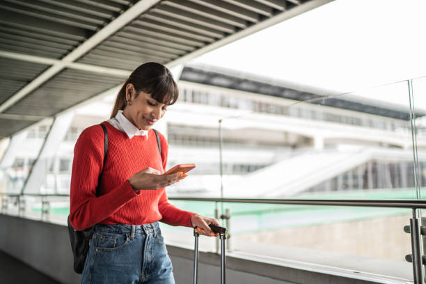 reisende junge frau mit handy in einer u-bahn-station - travel stock-fotos und bilder