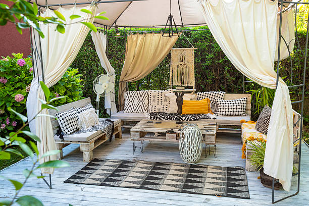 relaxing boho chic garden furniture under a gazebo creating a cozy outdoor space - garden decoration stock pictures, royalty-free photos & images