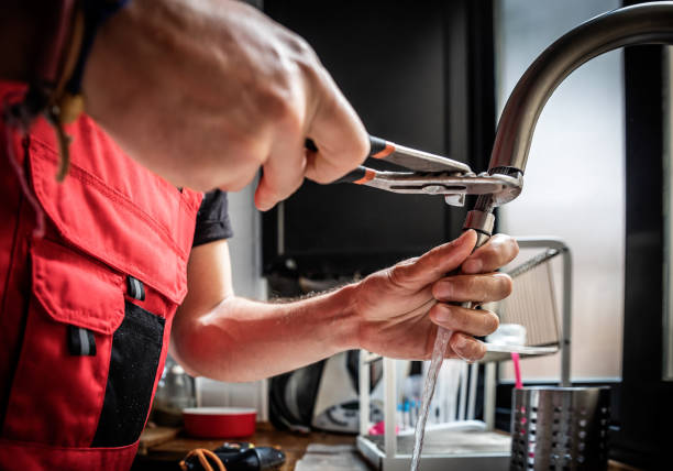repairman using adjustable pliers to fix kitchen faucet - home decoration stockfoto's en -beelden