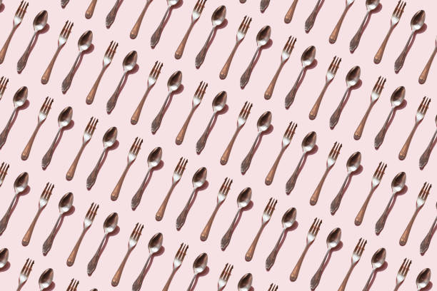 repeated spoon and fork on the pink background - food stock pictures, royalty-free photos & images