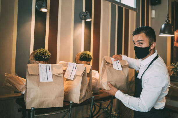 restaurant employer prepairing packed food for taking away. reopening after covid-19 quarantine concepts. - junk food stock pictures, royalty-free photos & images