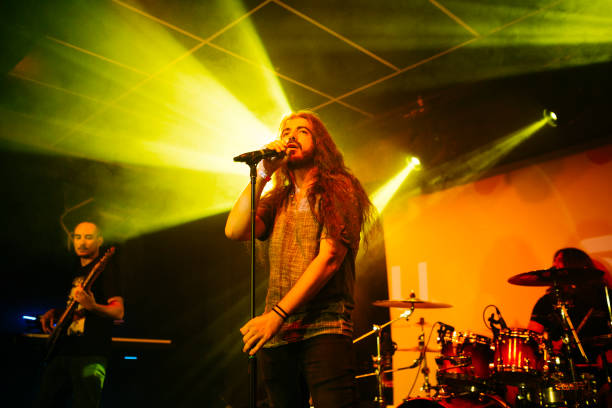 rock band performing on stage at night club - concert stock pictures, royalty-free photos & images