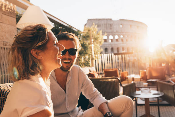 romantic couple having fun at sunset in rome, italy. colosseum and sunstar - travel stock pictures, royalty-free photos & images