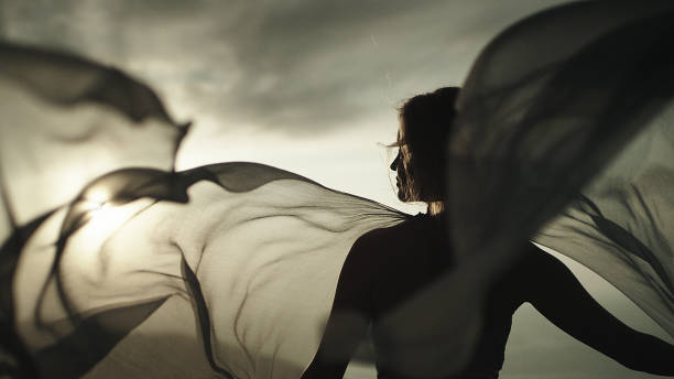 romantic girl in long dress enjoying the wind. standing on a cliff - fashion stock pictures, royalty-free photos & images