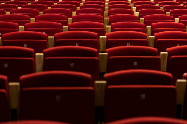 row of numbered theater seats in red velvet, with wooden armrests. theater, opera, show, artist, director and entertainment concept. - concert stock pictures, royalty-free photos & images