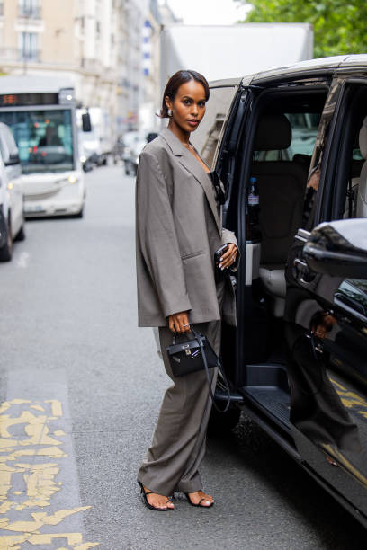 Sabrina Dhowre Elba is seen wearing grey blazer, pants, black Hermes bag outside Bianca Saunders during the Menswear Spring/Summer 2025 as part of...