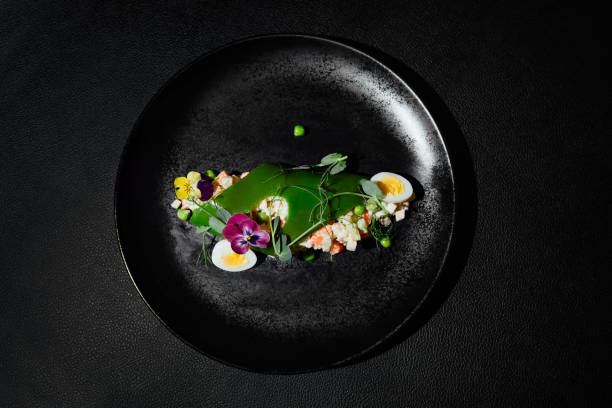 salad on a black plate on a black background - food stock pictures, royalty-free photos & images