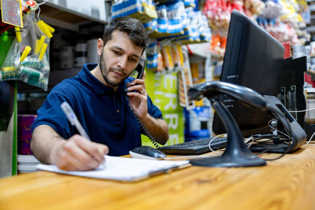 salesman working at a hardware store taking an order on the phone - home decoration stock pictures, royalty-free photos & images