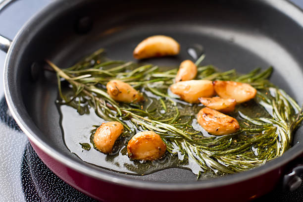 sauteed garlic and rosemary in olive oil - food stock pictures, royalty-free photos & images