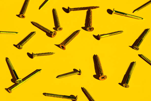 scattered screw nails on yellow color background. - nails art photos et images de collection