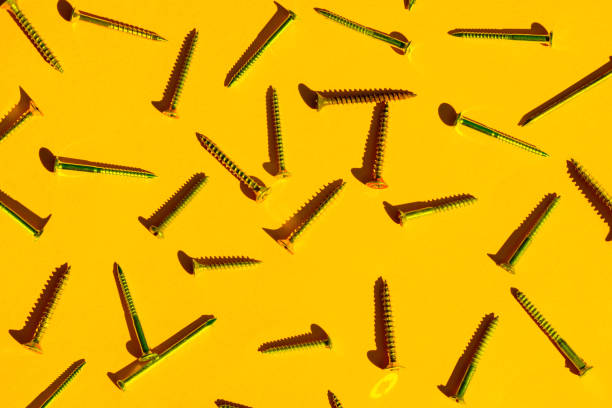 scattered screw nails on yellow orange color background. - nails art stock pictures, royalty-free photos & images