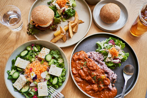 scene at a table with a couple enjoying lunch at a vegan cafe. - food stock pictures, royalty-free photos & images