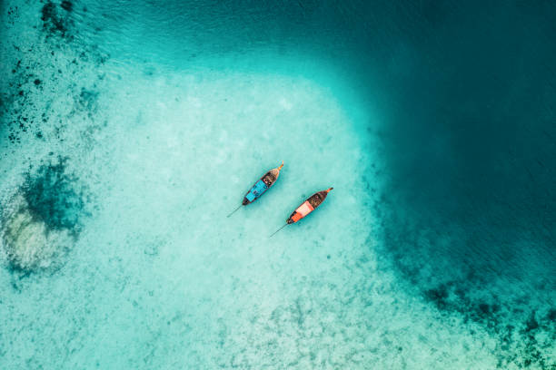 scenic aerial view of two boats on sea in thailand - travel stock pictures, royalty-free photos & images