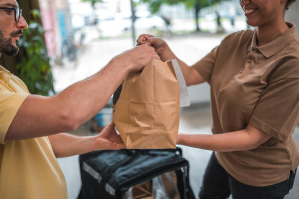 seamless meal service for a mid adult male employee in a modern office - junk food stock pictures, royalty-free photos & images