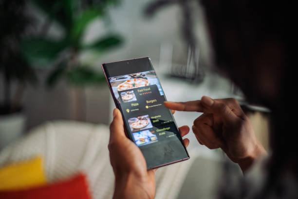 selecting fast food options on a tablet - junk food stock pictures, royalty-free photos & images