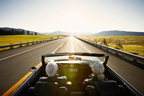 senior couple driving convertible car at sunrise - travel stock pictures, royalty-free photos & images