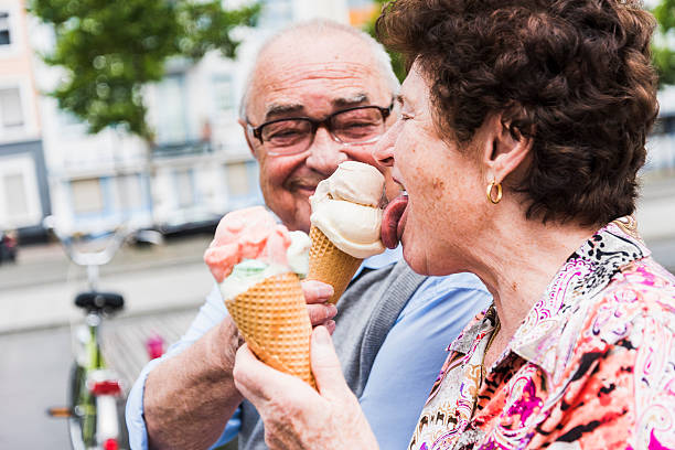 senior couple enjoy eating ice cream together - food stock pictures, royalty-free photos & images