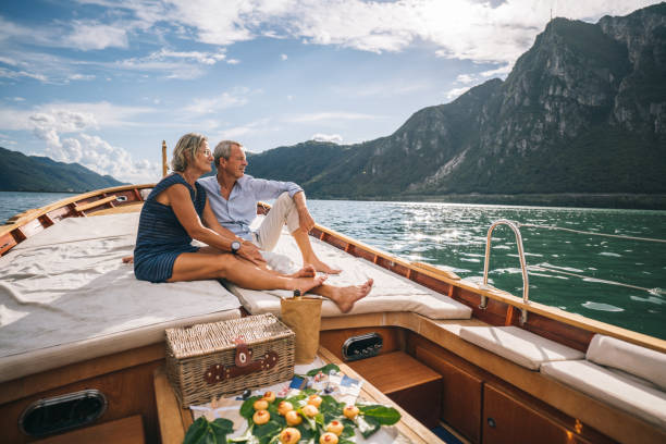senior couple enjoy time together on boat, lake lugano - travel stock pictures, royalty-free photos & images