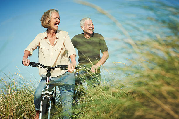 senior couple enjoying day out on their bicycles - travel stock pictures, royalty-free photos & images