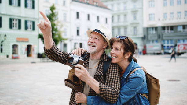 senior couple travelers sightseeing in city. - travel stock pictures, royalty-free photos & images