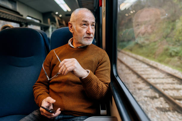 senior man enjoying a view while riding in a train - travel stock pictures, royalty-free photos & images