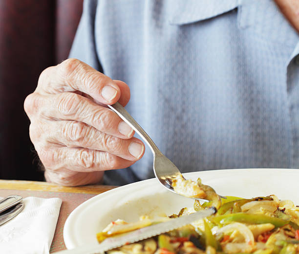 senior man fingers holding breakfast fork close-up - food stock pictures, royalty-free photos & images