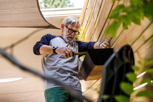 senior man installing planter on patio - home decoration fotografías e imágenes de stock
