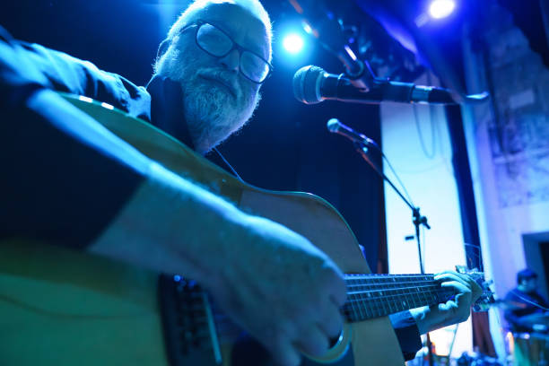 senior man playing guitar on stage during a concert - concert stock pictures, royalty-free photos & images