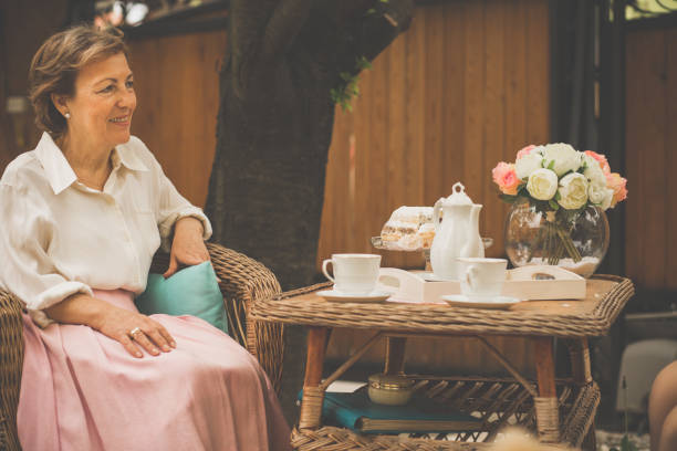 senior woman having tea in the garden - garden decoration stock pictures, royalty-free photos & images