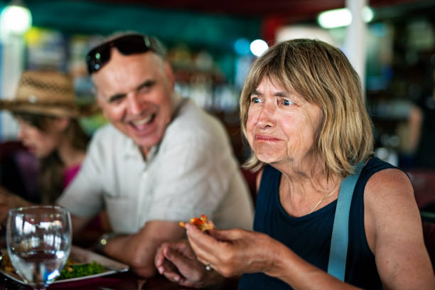 senior woman tries a new dish in a restaurant. - food stock pictures, royalty-free photos & images
