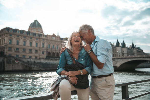 seniors taking a break in paris relaxing by the seine river in paris - travel stock pictures, royalty-free photos & images