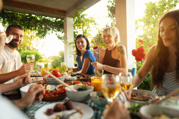 serene caucasian friends, enjoying the brunch in the garden - food stock pictures, royalty-free photos & images