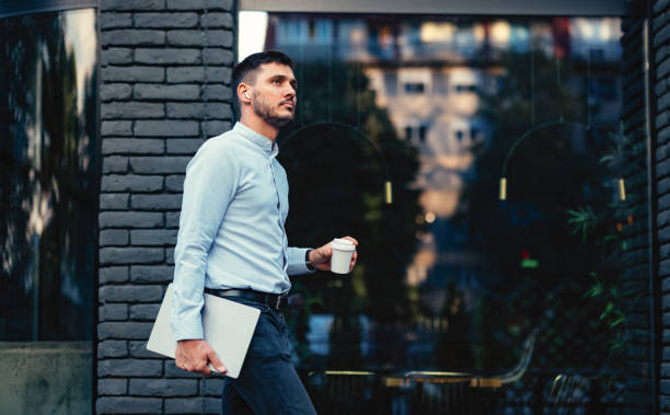 serious businessman walking at the city street - junk food stock pictures, royalty-free photos & images