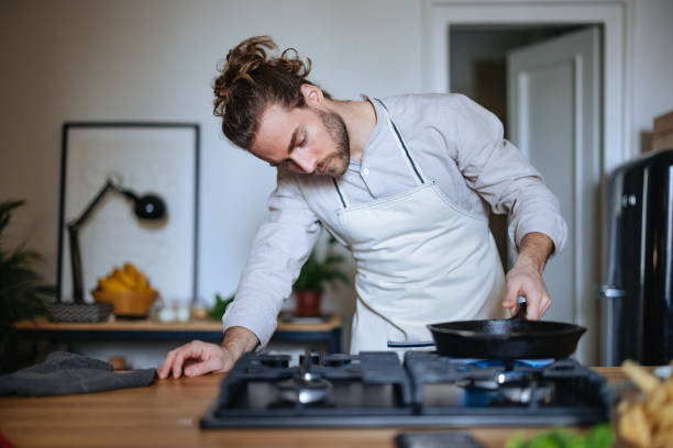 serious man making a healthy meal in the kitchen - food stockfoto's en -beelden