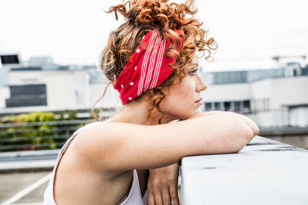 serious redheaded woman leaning on wall - hairstyle stock pictures, royalty-free photos & images