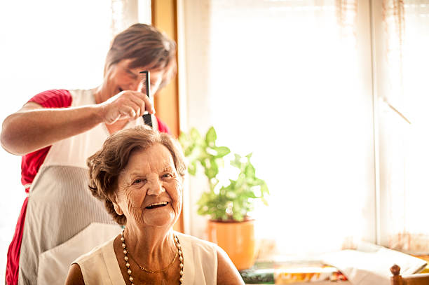 servicio de cuidado en el hogar para ancianos por un cuidador - hairstyle fotografías e imágenes de stock