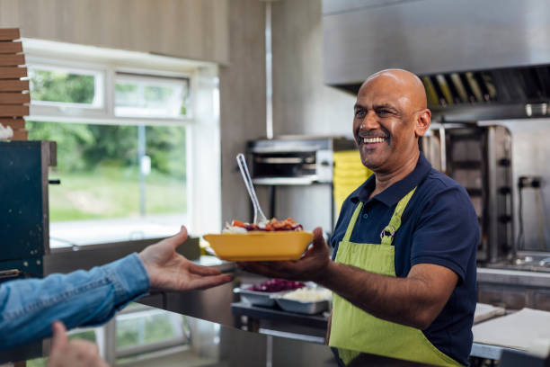 serving a customer at a takeaway shop - junk food stock pictures, royalty-free photos & images