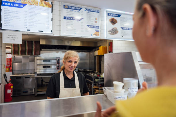 serving customer at chip shop - junk food stock pictures, royalty-free photos & images
