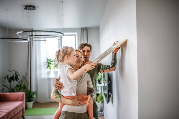 shared family tasks: decorating and moving into a new apartment as a team - home decoration stock pictures, royalty-free photos & images
