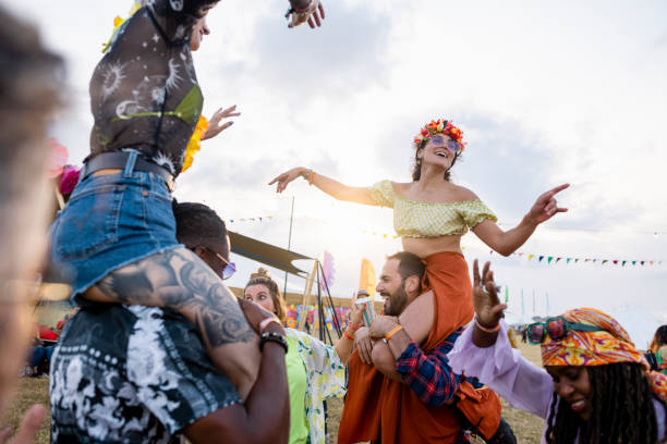 sharing a shoulder carry at the festival - concert stock pictures, royalty-free photos & images