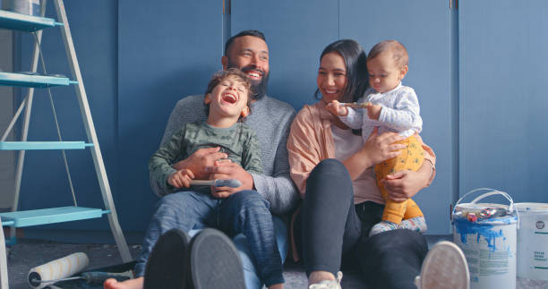 shot of a young couple sitting with their two sons in a room undergoing renovations - home decoration stock pictures, royalty-free photos & images