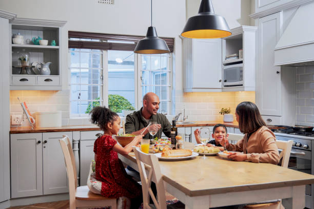 shot of a young family enjoying a meal together - food stock pictures, royalty-free photos & images
