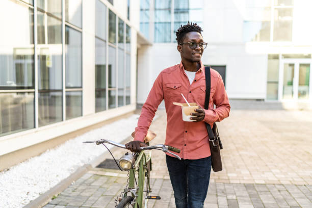 shot of a young man using a bicycle outdoors - junk food stock pictures, royalty-free photos & images