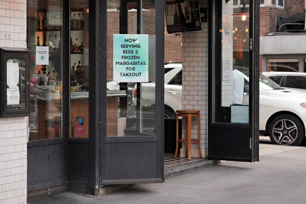 Sign in a restaurant window advertises beer and margaritas for takeout during the coronavirus pandemic on May 19, 2020 in New York City. COVID-19 has...