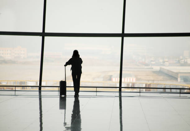 silhouette of travelers in airport - travel photos et images de collection