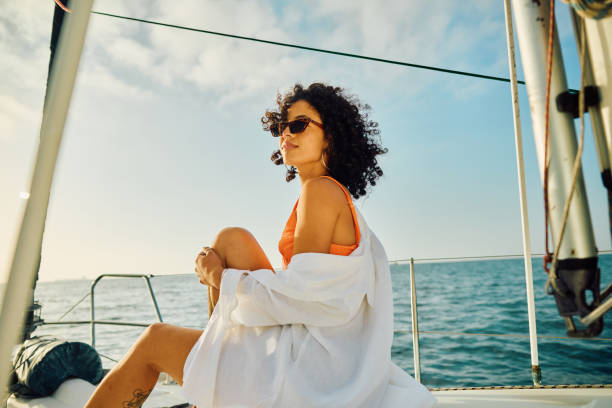single young female experiences serene travel at sea - travel photos et images de collection