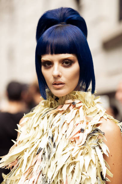 Sita Abellan with blue hair wears light pink yellow and green colour dress outside Marni during the Milan Fashion Week Spring/Summer 2025 on...